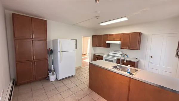 a kitchen with stainless steel appliances granite countertop a refrigerator a stove a sink and a refrigerator