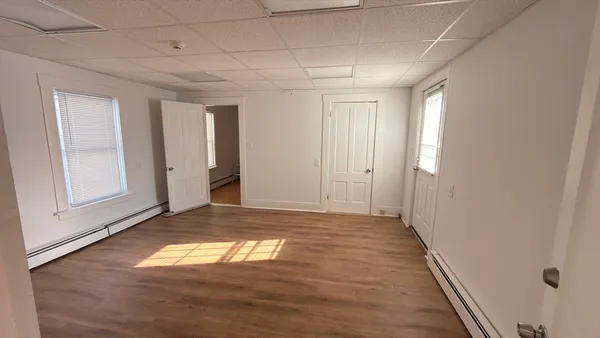 a view of empty room with wooden floor