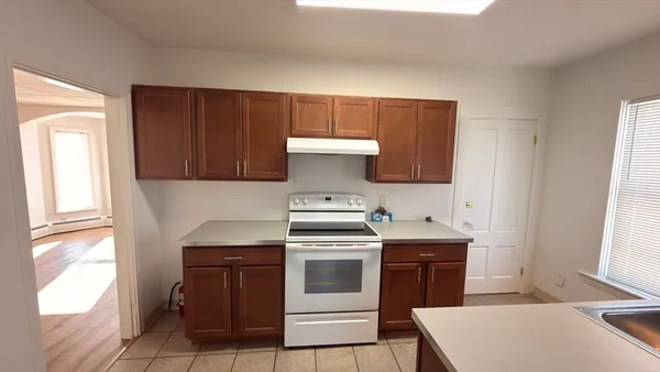 a kitchen with a stove top oven sink and window