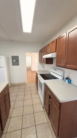 a kitchen with a sink a stove top oven and white cabinets