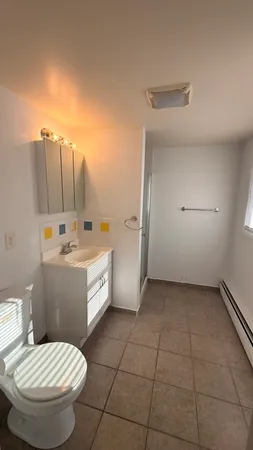 a bathroom with a granite countertop toilet sink and mirror