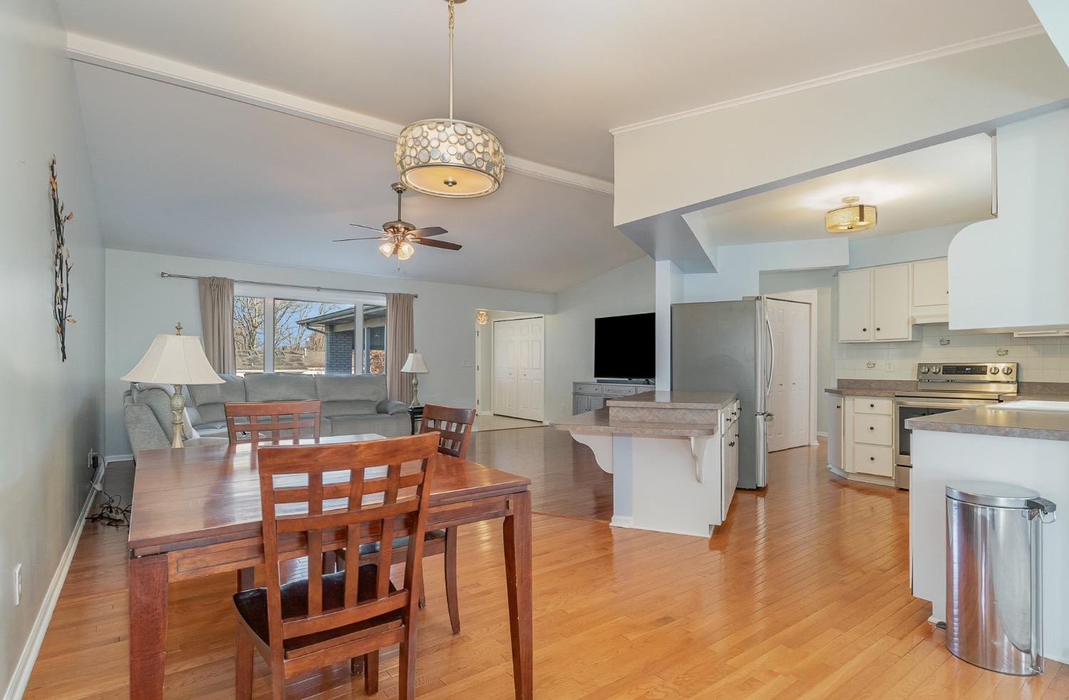 1286 Brandywine Road Crown Point, IN 46307 - Photo 9 of 30 a view of a dining room and livingroom with furniture wooden floor a rug a fireplace and a chandelier