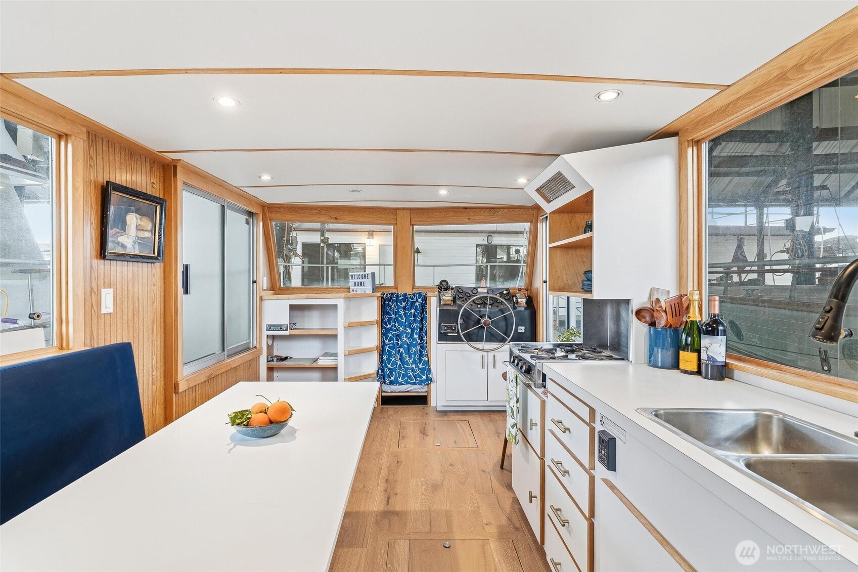 2401 North Northlake Way Seattle, WA 98103 - Photo 4 of 25 a view of a kitchen with kitchen island a large window cabinets a sink and stainless steel appliances
