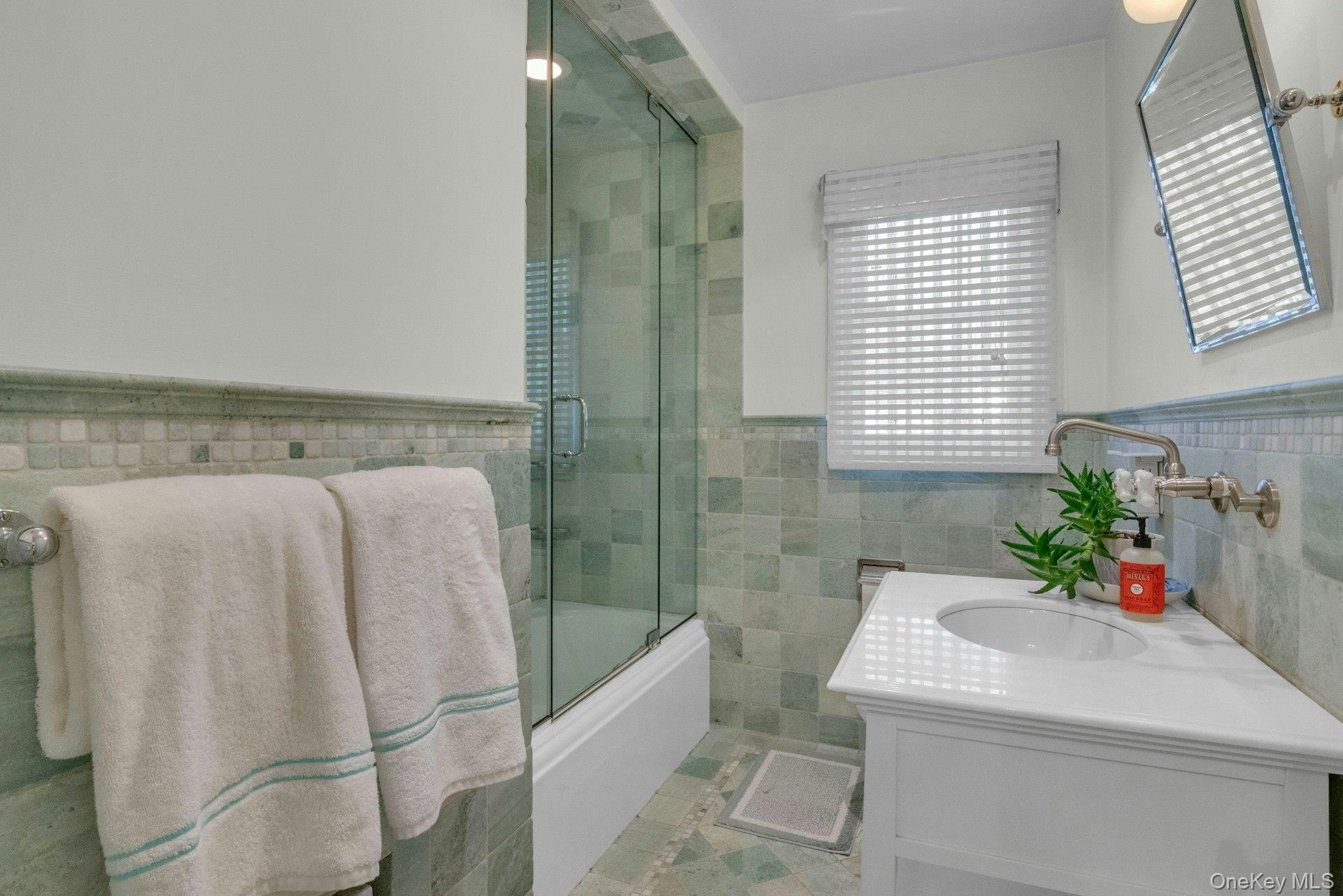 31 Orchard Road Briarcliff Manor, NY 10510 - Photo 13 of 33 a bathroom with a sink and mirror with bathtub