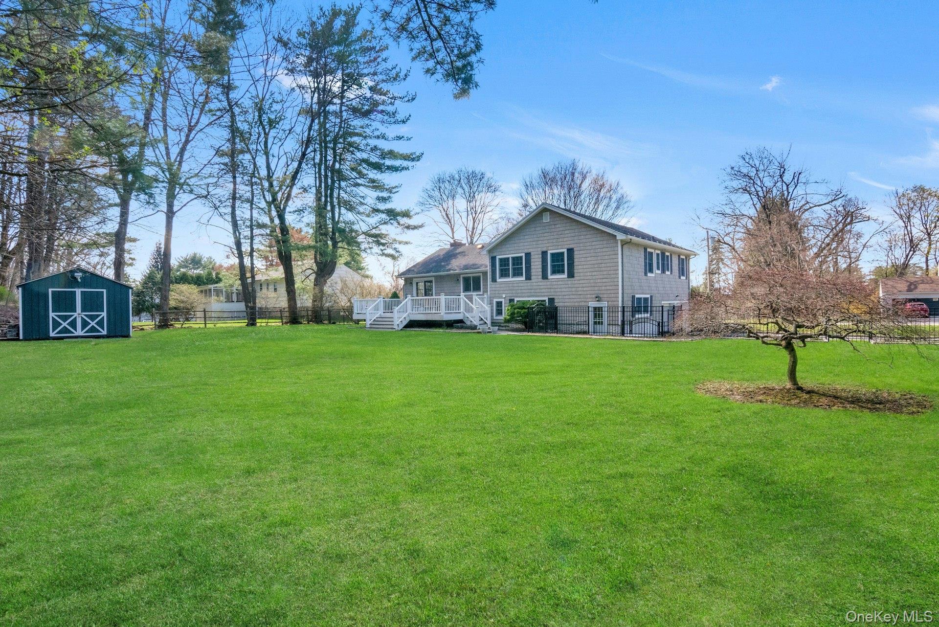 31 Orchard Road Briarcliff Manor, NY 10510 - Photo 24 of 33 a house that is sitting in the grass with large trees and plants
