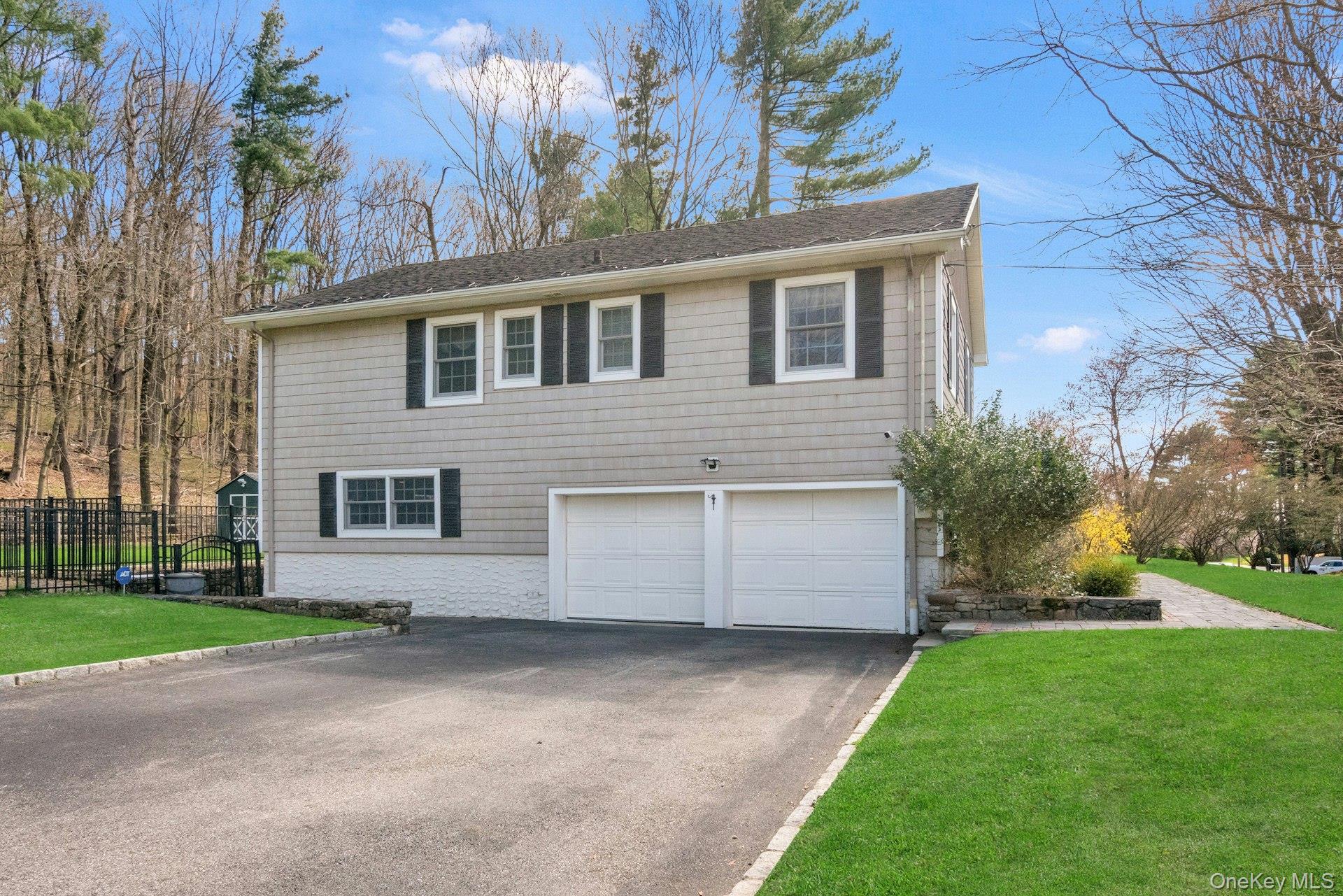 31 Orchard Road Briarcliff Manor, NY 10510 - Photo 28 of 33 a front view of a house with a yard and garage