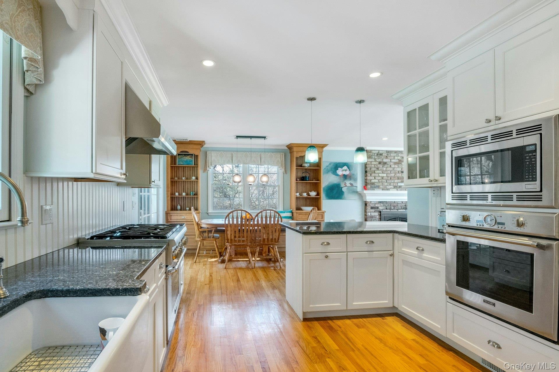 31 Orchard Road Briarcliff Manor, NY 10510 - Photo 6 of 33 a kitchen with stainless steel appliances kitchen island granite countertop a stove a sink and white cabinets with wooden floor