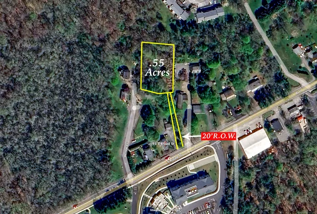 a view of white house in middle of forest