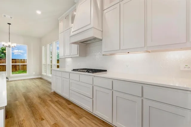 a kitchen with granite countertop white cabinets and stainless steel appliances