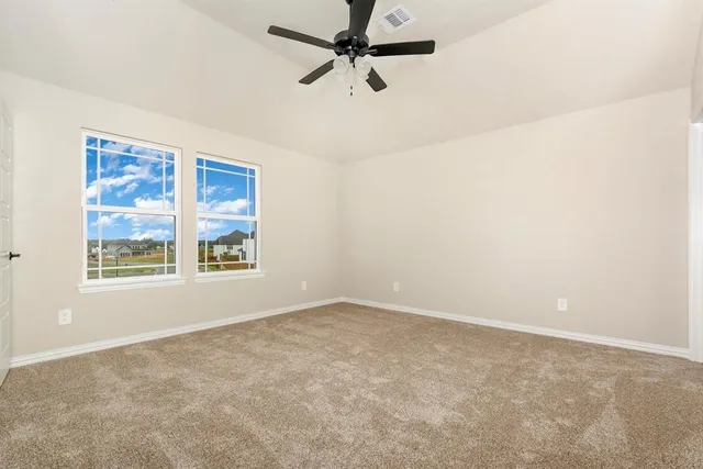 an empty room with windows and fan