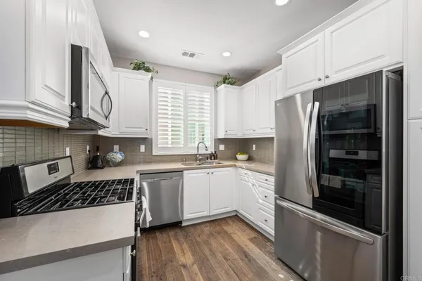 a kitchen with a refrigerator a sink and cabinets