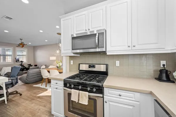a kitchen with stainless steel appliances granite countertop a stove a white cabinet and a granite counter tops