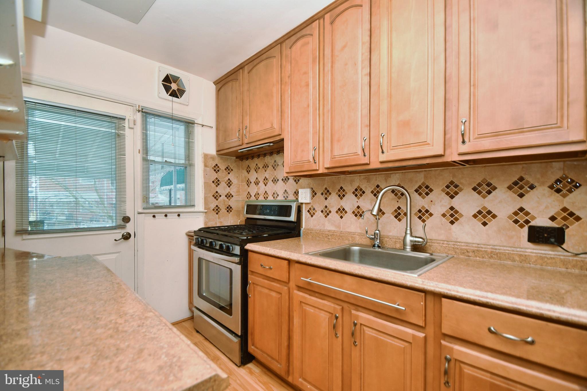 1041 Arncliffe Road Baltimore, MD 21221 - Photo 10 of 40 a kitchen with stainless steel appliances granite countertop white cabinets and a stove top oven