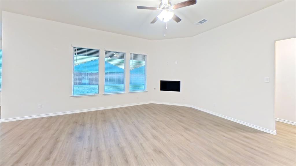 2117 Eugene Street Anna, TX 75409 - Photo 17 of 31 Spare room with a ceiling fan, light wood-type flooring, and a fireplace