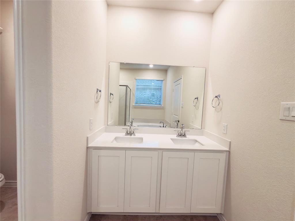 2117 Eugene Street Anna, TX 75409 - Photo 29 of 31 Full bath featuring double vanity, a textured wall, and a stall shower