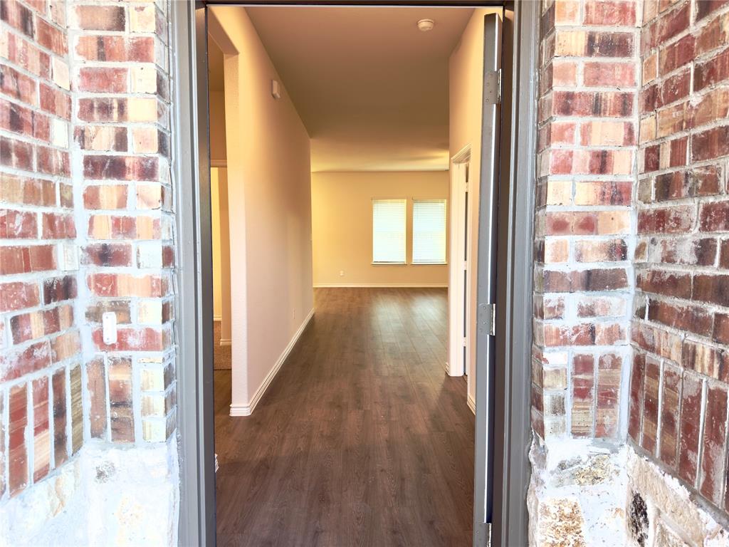 2117 Eugene Street Anna, TX 75409 - Photo 3 of 31 Hallway with brick wall and dark wood finished floors