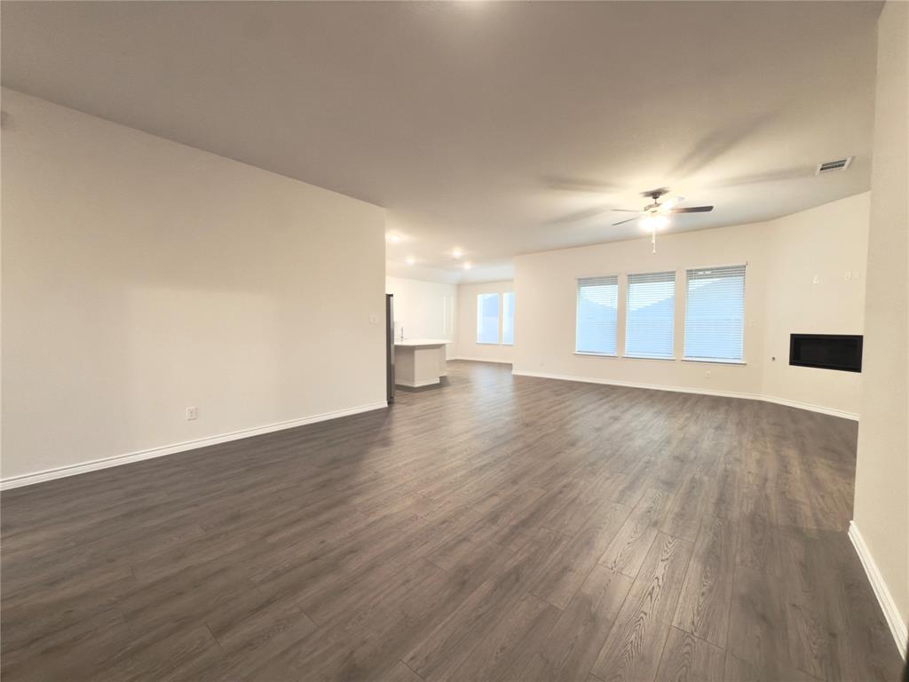 2117 Eugene Street Anna, TX 75409 - Photo 10 of 31 Unfurnished living room with a fireplace, dark wood finished floors, and ceiling fan