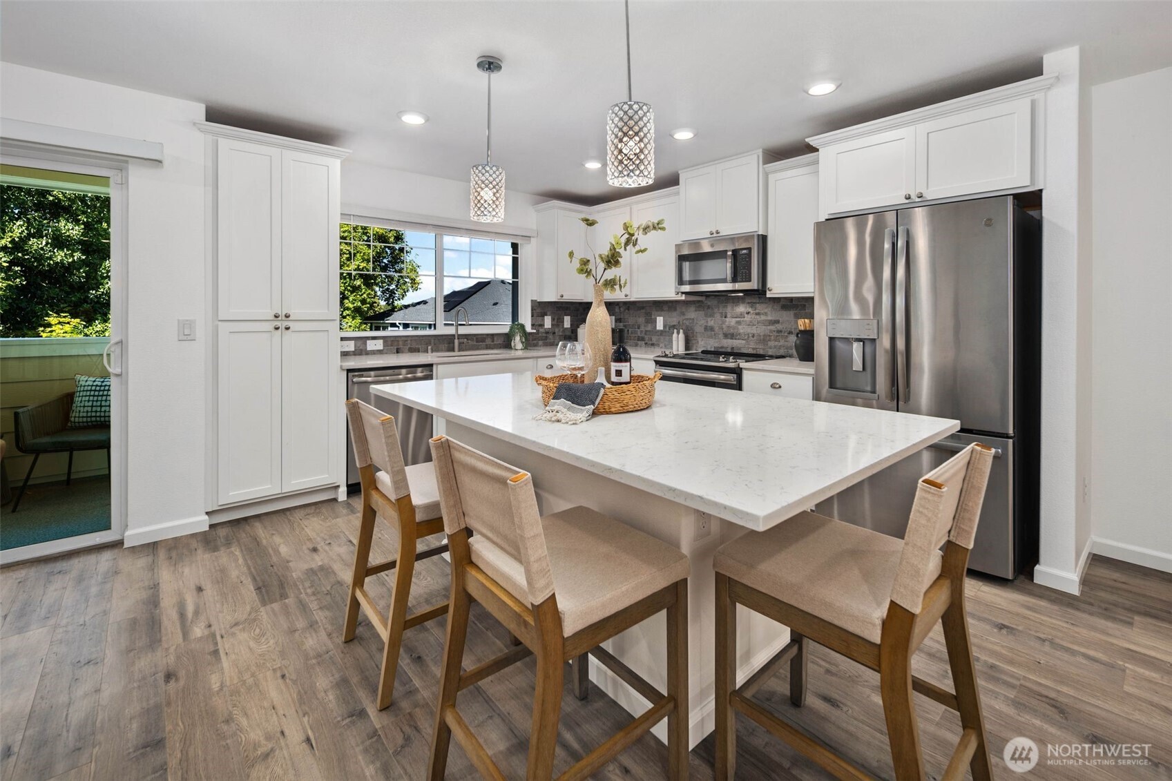 6561 30th Place Southwest Seattle, WA 98126 - Photo 13 of 37 a kitchen with a dining table chairs refrigerator and microwave