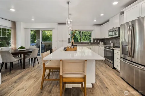 a kitchen with a table chairs refrigerator and microwave