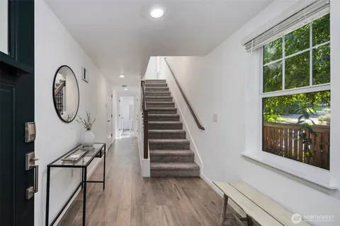 a view of a hallway with wooden floor and white walls