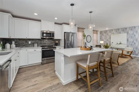 a kitchen with kitchen island granite countertop a sink a counter top space stainless steel appliances and cabinets