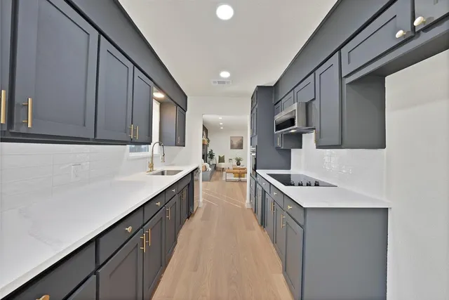 a kitchen with stainless steel appliances a sink dishwasher stove refrigerator and cabinets
