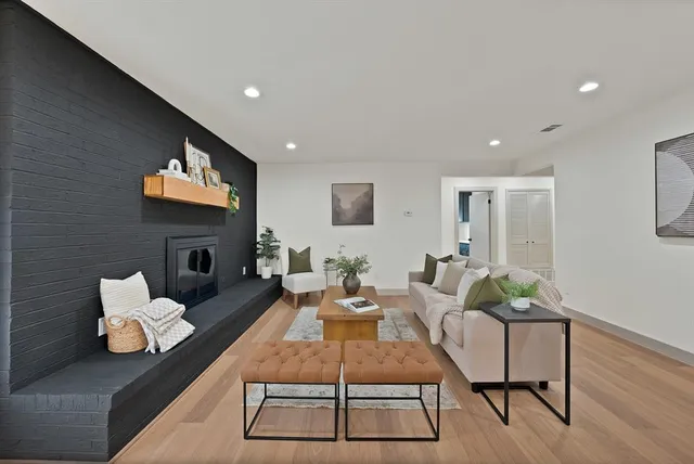 a living room with furniture fireplace and wooden floor