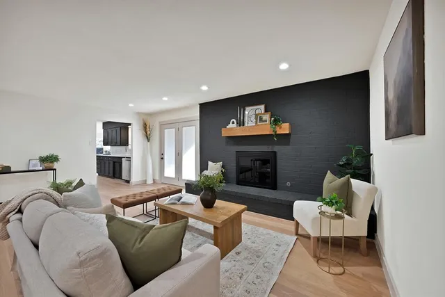 a living room with furniture a fireplace and a flat screen tv