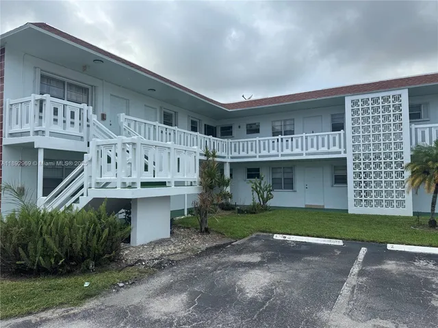 a view of a house with a yard and potted plants