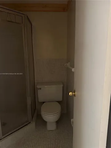 a white toilet sitting next to a shower