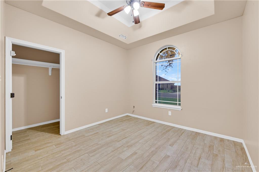 2005 Stuart Road Weslaco, TX 78599 - Photo 17 of 30 an empty room with wooden floor fan and windows