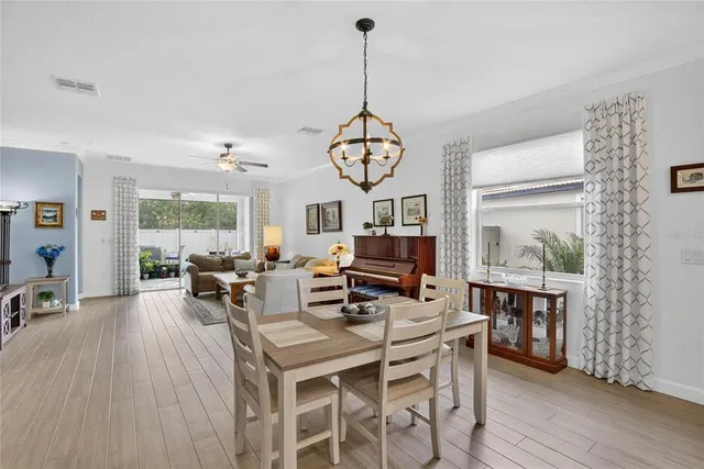 a view of a livingroom with furniture entryway wooden floor and a chandelier