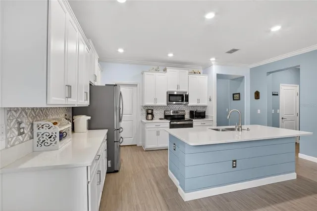 a view of a dining room and livingroom with furniture wooden floor a chandelier