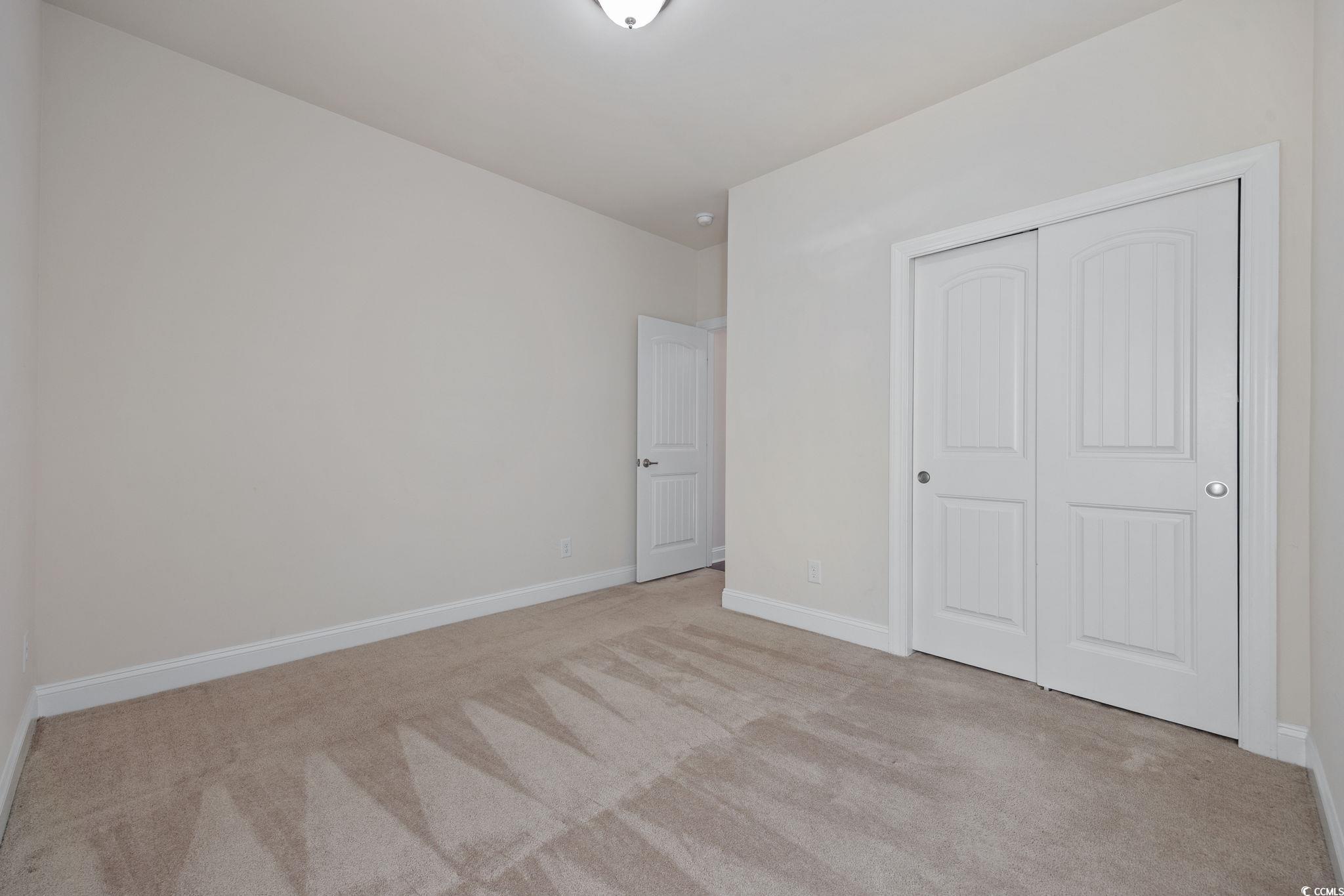1900 Bluff Drive Myrtle Beach, SC 29577 - Photo 17 of 38 Unfurnished bedroom featuring light carpet and a closet