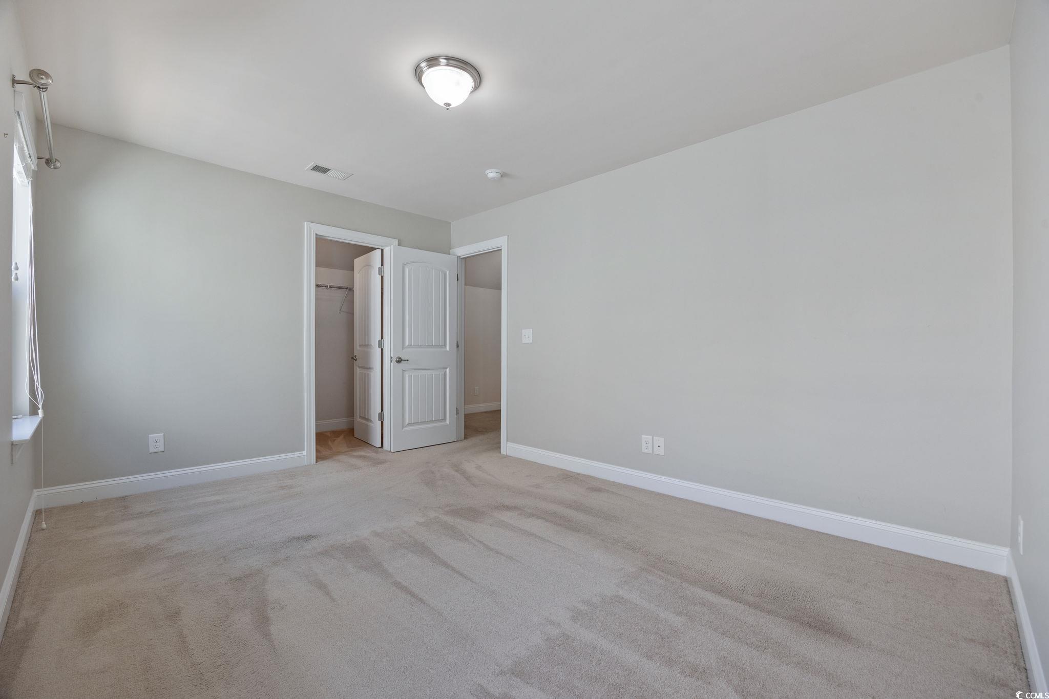 1900 Bluff Drive Myrtle Beach, SC 29577 - Photo 23 of 38 Unfurnished bedroom with a walk in closet and light colored carpet