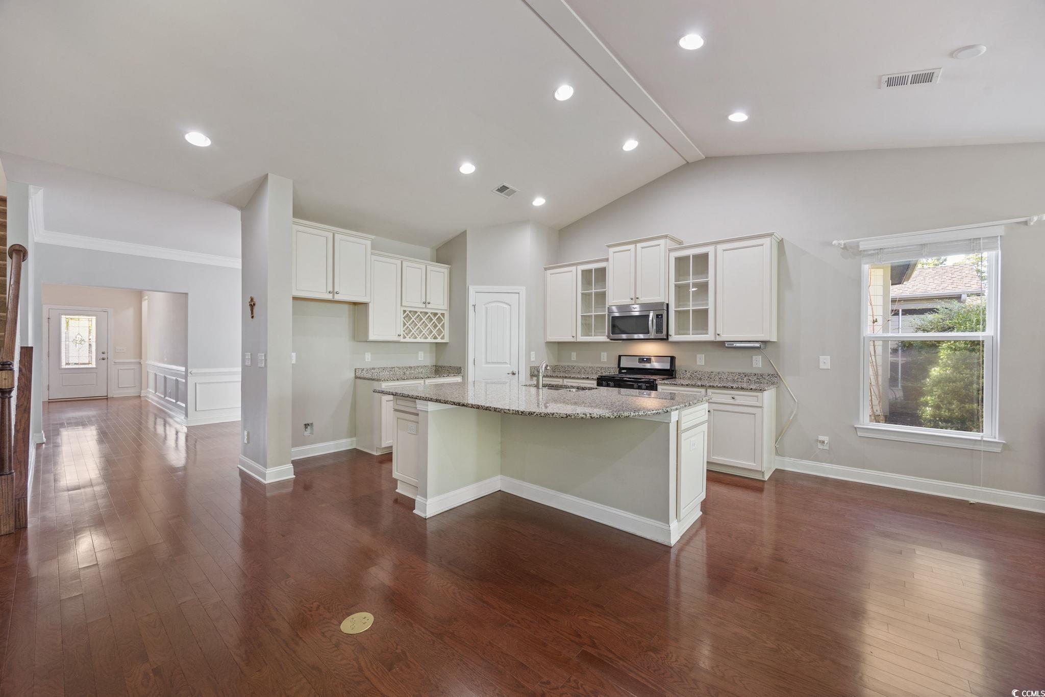 1900 Bluff Drive Myrtle Beach, SC 29577 - Photo 8 of 38 Kitchen featuring glass insert cabinets, dark wood-type flooring, white cabinets, range, and light stone countertops