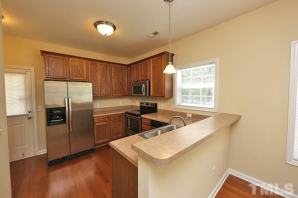 2014 Lime Street Durham, NC 27704 - Photo 6 of 17 a kitchen with stainless steel appliances granite countertop a sink a stove a refrigerator cabinets wooden floor and a window