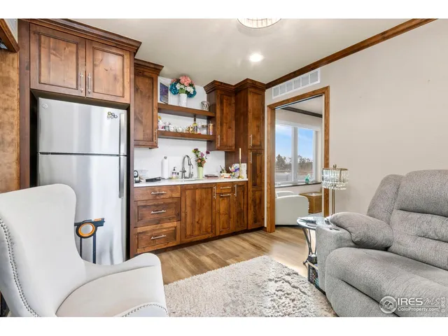a living room with a couch and a dresser with kitchen view