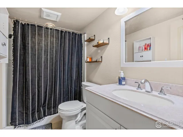 a bathroom with a sink a toilet and shower curtain