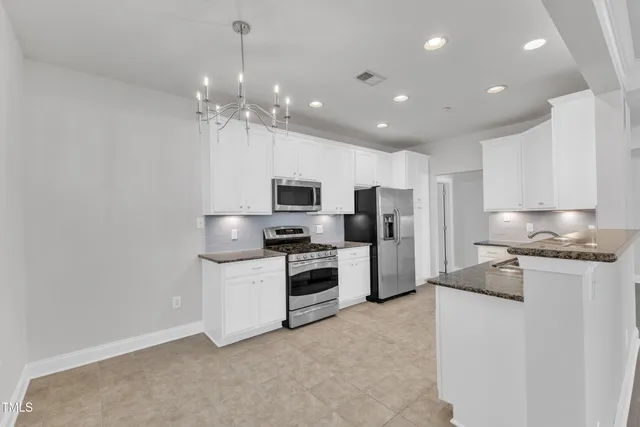 a kitchen with stainless steel appliances a refrigerator sink and microwave