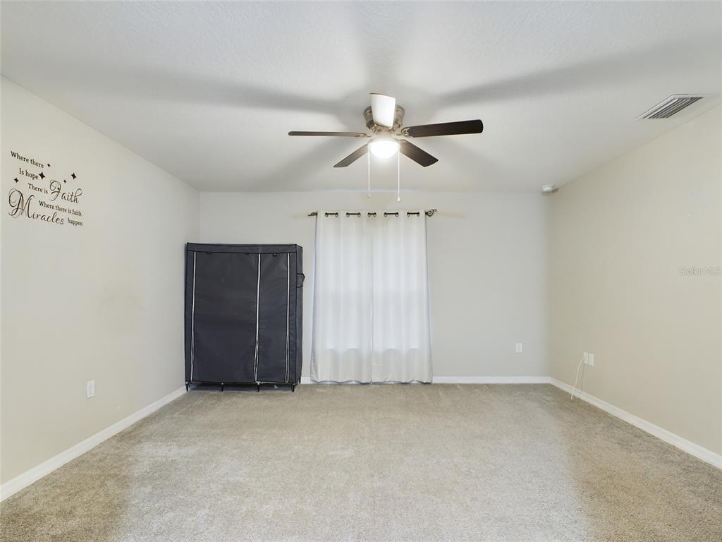 10102 Southwest 188th Circle Dunnellon, FL 34432 - Photo 11 of 17 an empty room with a ceiling fan and a window