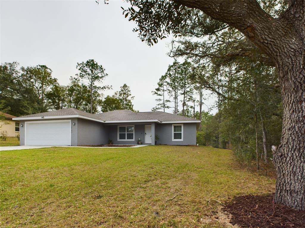 10102 Southwest 188th Circle Dunnellon, FL 34432 - Photo 2 of 17 a white house that has a tree in front of it