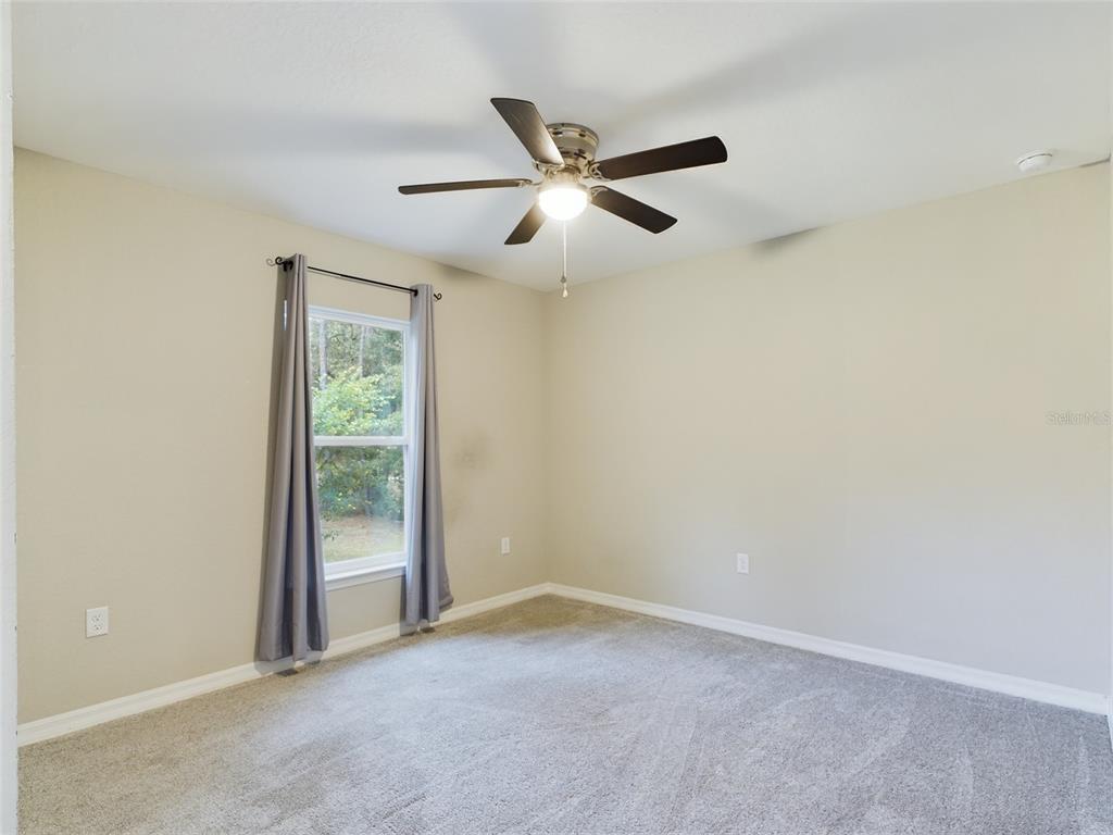 10102 Southwest 188th Circle Dunnellon, FL 34432 - Photo 7 of 17 an empty room with a ceiling fan and window