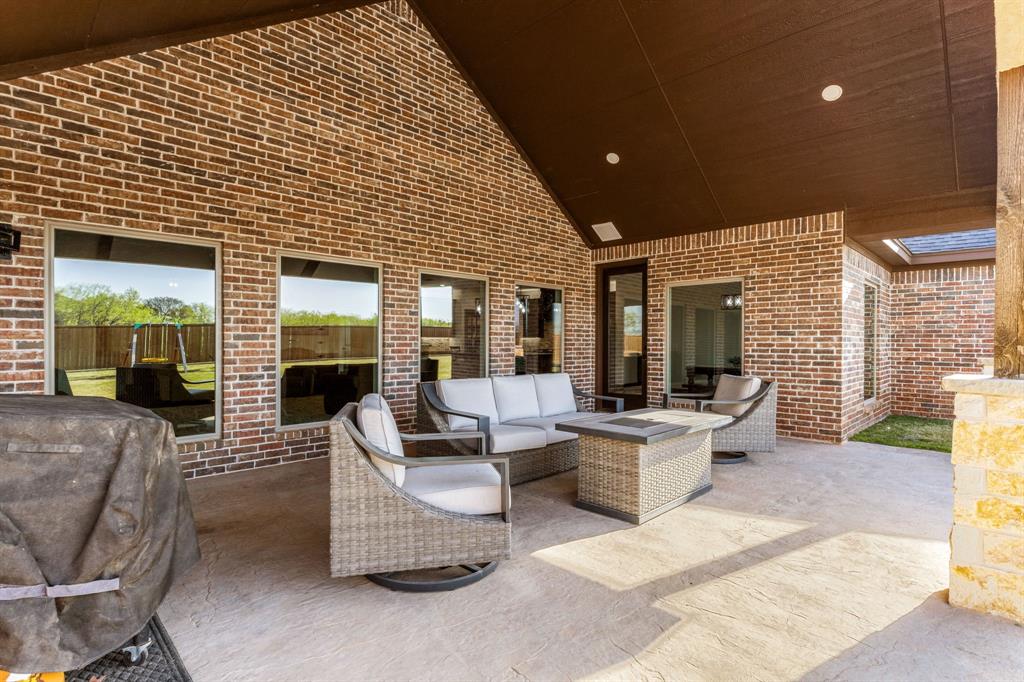 515 Sales Road Windthorst, TX 76389 - Photo 3 of 34 a view of a patio with couches chairs potted plants and floor to ceiling window