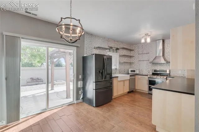 a kitchen with stainless steel appliances granite countertop a refrigerator and a stove top oven