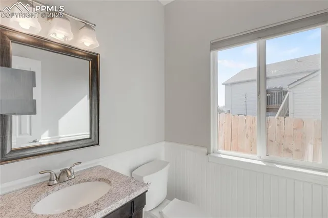 a bathroom with a granite countertop sink a mirror and a window