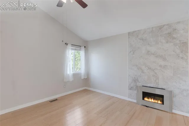 an empty room with windows and fireplace