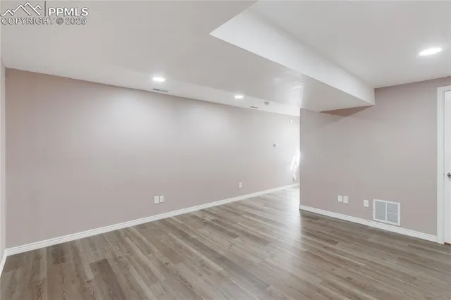 a view of an empty room with wooden floor