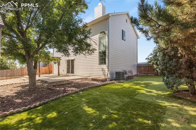 a view of a yard in front of a house with large tree