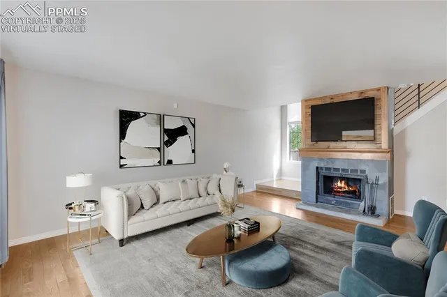 a living room with furniture a fireplace and a flat screen tv